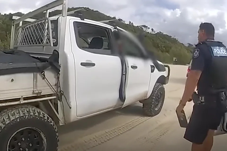 Police approach ute on Sunshine Coast beach.