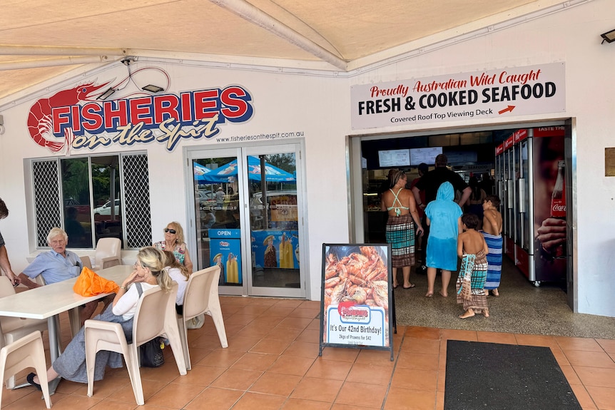 Customers at the entrance of a seafood shop.