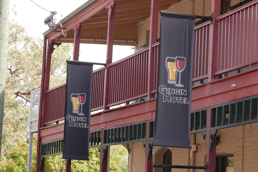 Black banners with the words 'Gingin Hotel' hang off the side of a pub building.