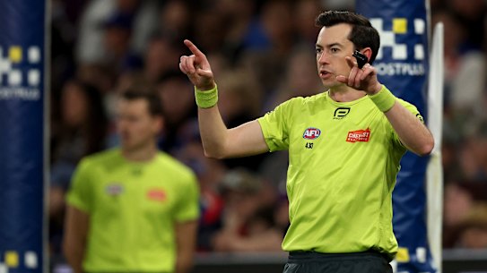 Field umpire Andrew Stephens signals for a goal review last season.