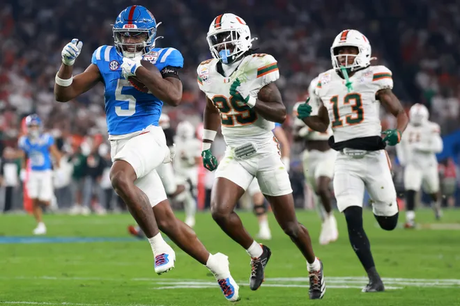Jan 8, 2026; Glendale, AZ, USA; Mississippi Rebels running back Kewan Lacy (5) rushes the ball for a touchdown against Miami Hurricanes defensive back Jr. Romanas Frederique (29) in the first half during the 2026 Fiesta Bowl and semifinal game of the College Football Playoff at State Farm Stadium. Mandatory Credit: Mark J. Rebilas-Imagn Images