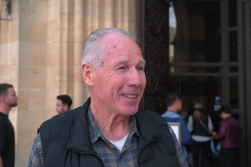 A churchgoer smiles and talks to a reporter