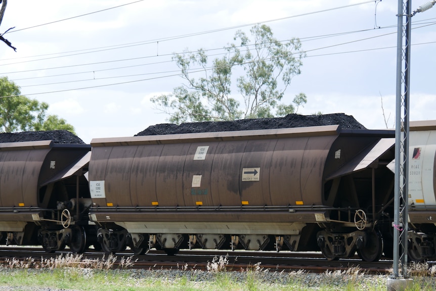 A train wagon filled precisely full with coal