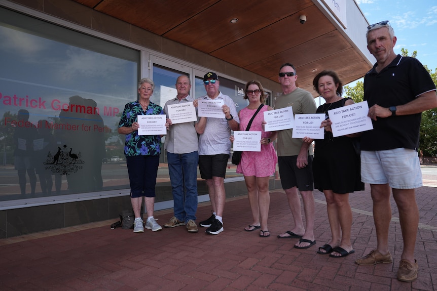 group holding posters outside office