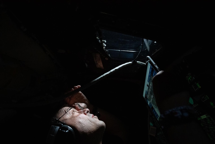 Commander Reid Wiseman peers out the window of the Orion spacecraft
