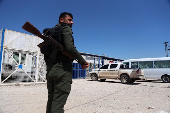 A soldier stands guard as vehicles arrive at al-Roj Camp in eastern Syria to transport Australian families to Damascus as part of a second repatriation effort.