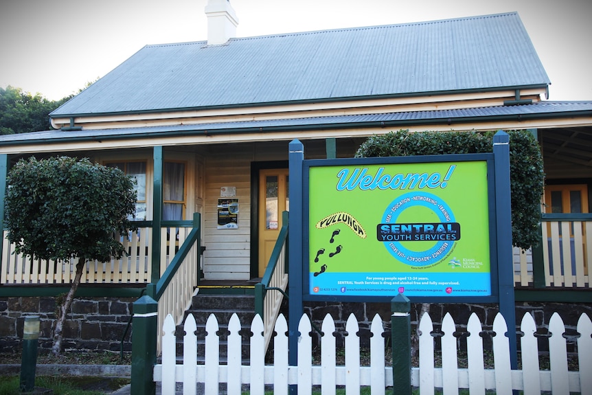 One-storey building with bright blue and green sign.