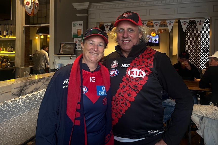 A woman and a man wearing Essedon gear in a pub