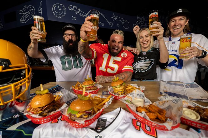 NFL fans at a Varsity watch party enjoying burgers and fries.