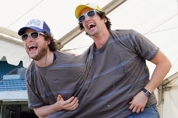 Hamish Blake and Andy Lee are doubled over laughing as they wear the same shirt