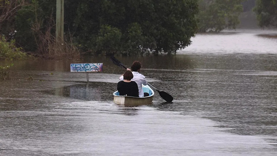 Residents paddle down a street in South Lismore, NSW, in March 2025