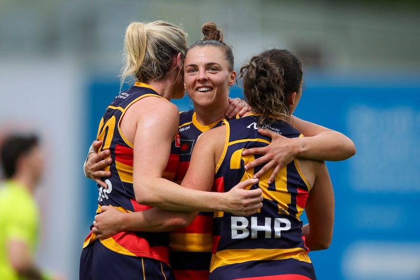 Amy Boyle-Carr, Ebony Marinoff and Grace Kelly of the Crows celebrate victory
