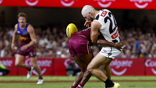 Steele Sidebottom of the Magpies is tackled by Keidean Coleman of the Lions.