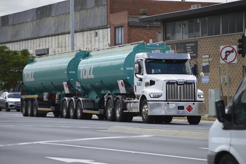 A petrol tanker driving down a road.