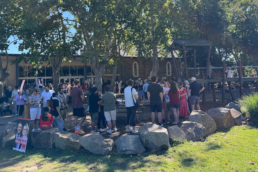 People lining up outside an old stone building