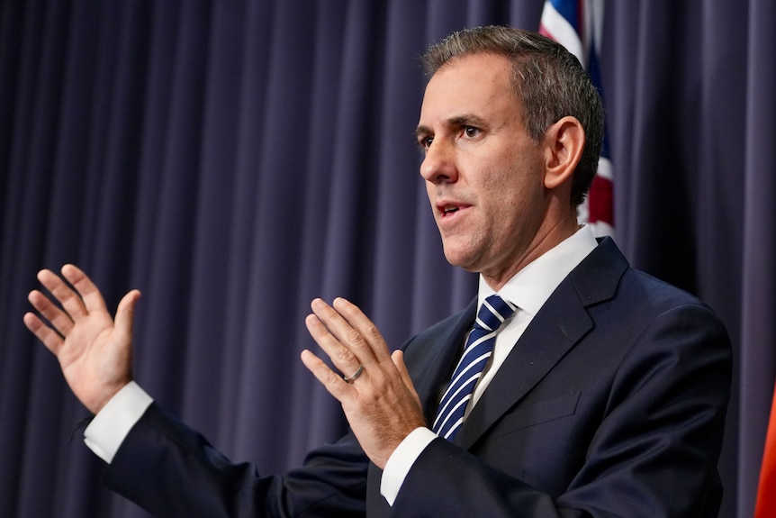 A man in a suit talks at a press conference