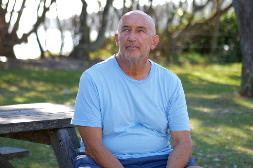 a bald man in a light blue t shirt
