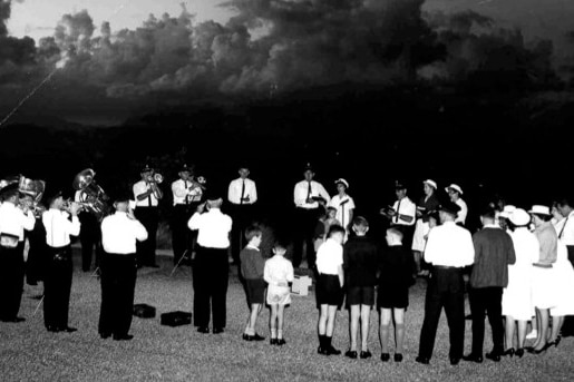 A black and white photo of people standing in a circle.