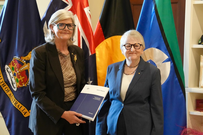 Sam Mostyn holds a copy of the interim report.