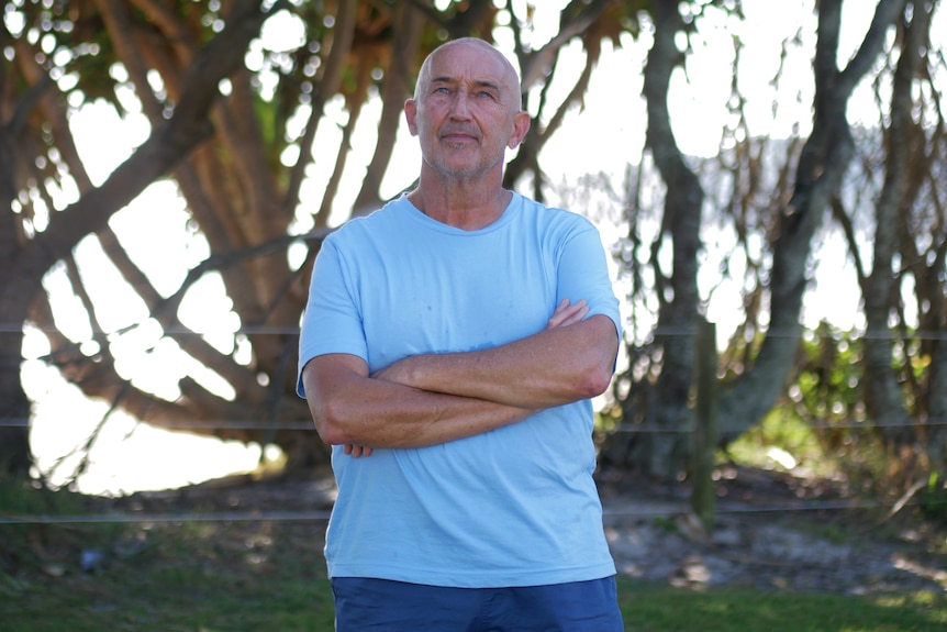 a bald man in a light blue t shirt