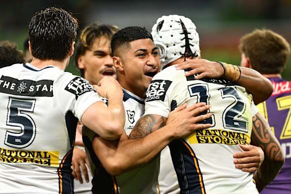 Josiah Karapani (centre) celebrates a try with Broncos teammates.