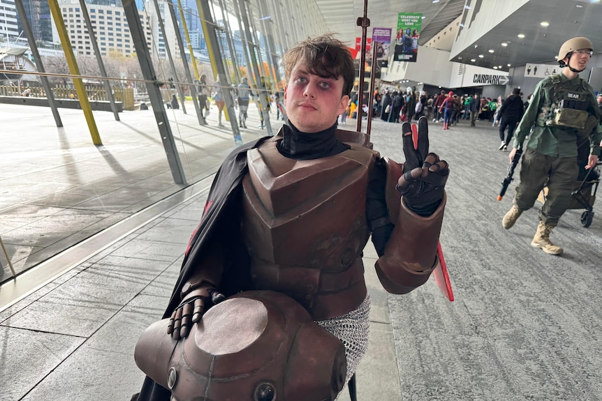 A cosplayer throwing up a peace sign