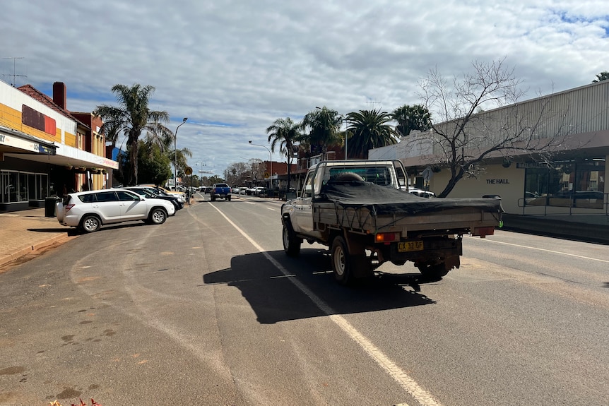 Ute driving down main street of rural town