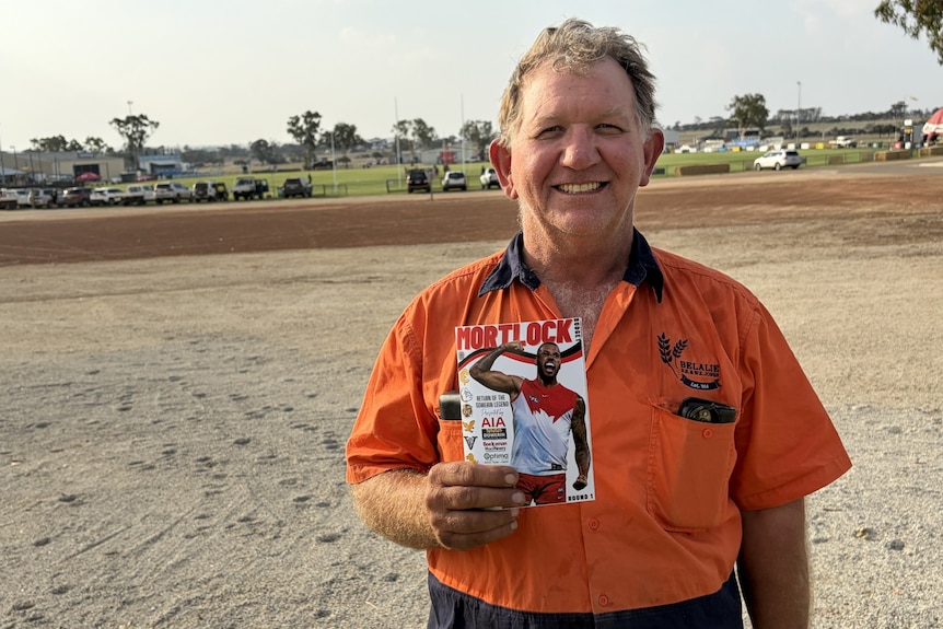 Ashley Jones holds a footy budget on the outskirts of Dowerin oval.