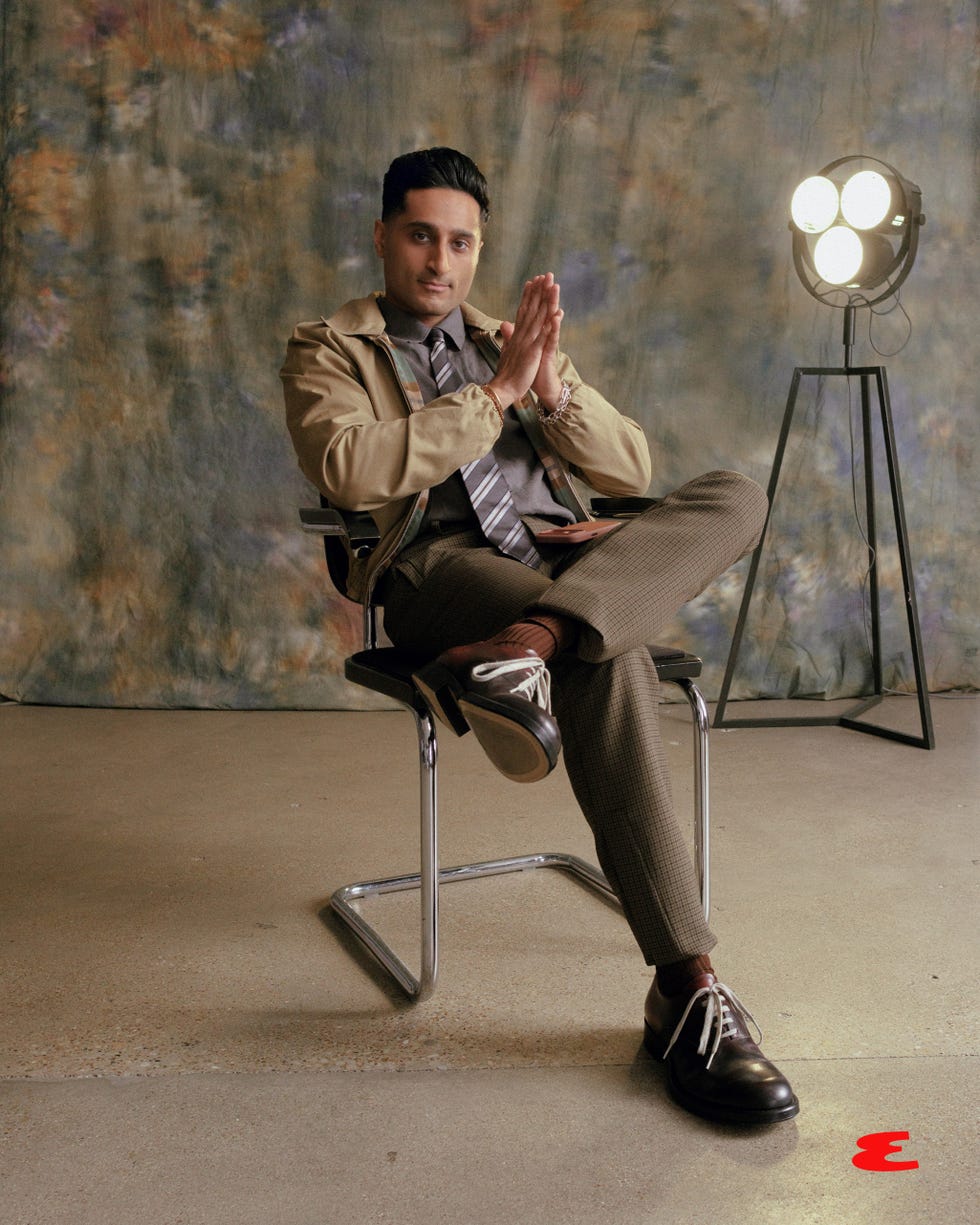 man seated in a chair hands clasped with studio lighting