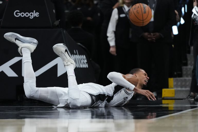 San Antonio Spurs forward Victor Wembanyama (1) takes a hard fall on the court during the first half in Game 2 of a first-round NBA playoffs basketball series against the Portland Trail Blazers in San Antonio, Tuesday, April 21, 2026. (AP Photo/Eric Gay)