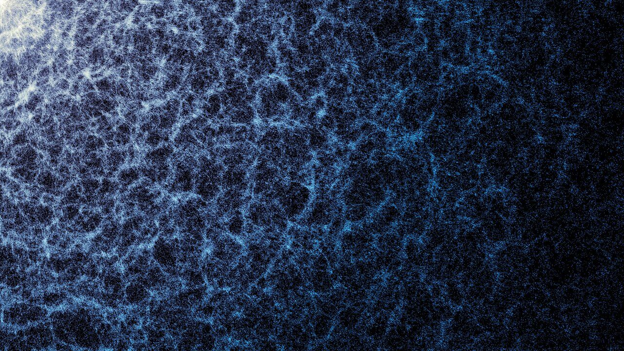 A blue and white map against a dark background. The denser areas indicate regions where galaxies and galaxy clusters have clumped together to form the strands of the cosmic web.