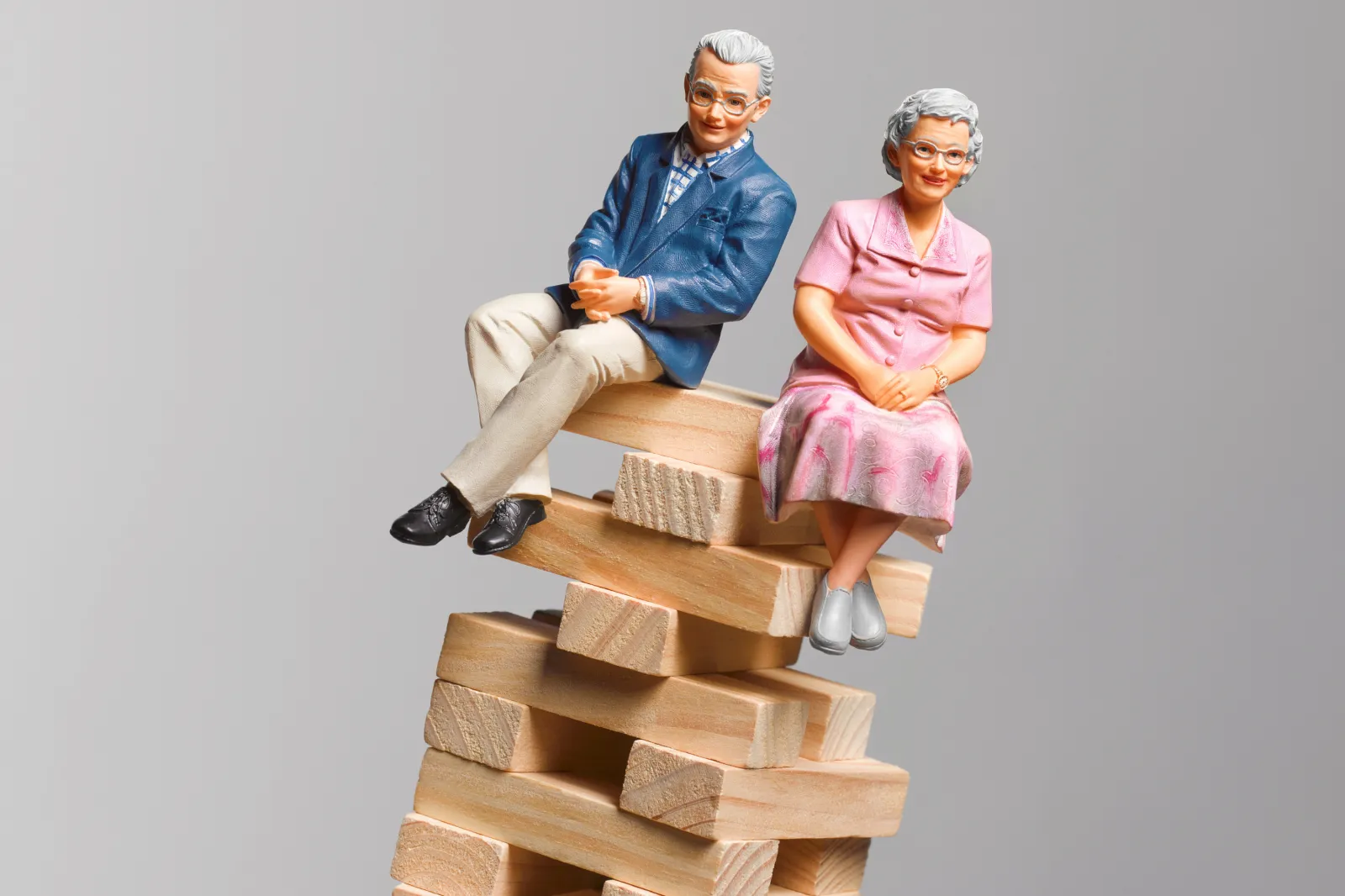 Pensioners sitting in a dangerous position unbalanced about to fall, implying problems with pensions falling in value and the cost of retirement - stock image - undated