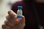 FILE - A medical doctor holds a vial of the combination measles, mumps and rubella vaccine at Prisma Health Pediatrics in Greer, S.C., on March 18, 2026.