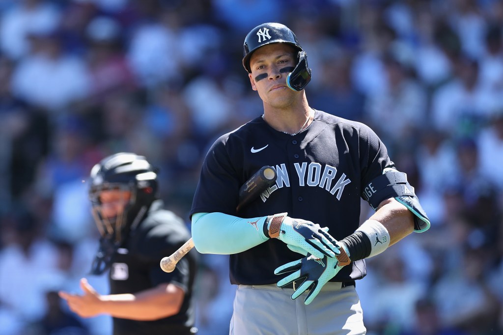 New York Yankees batter Aaron Judge at the plate, wearing black eye black, black helmet, and black jersey that says "NEW YORK".