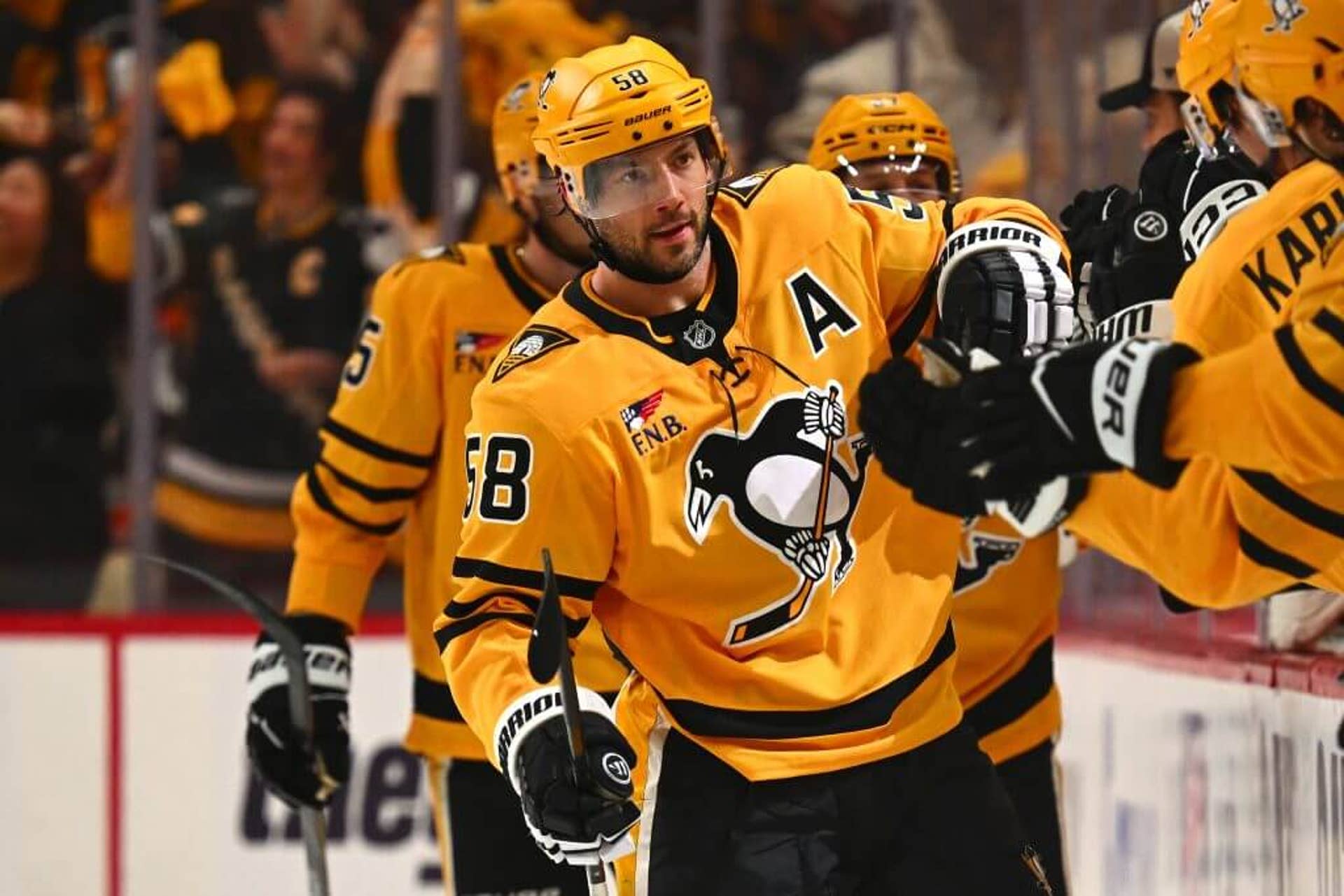 Letang fist bumps teammates on the Penguins bench.