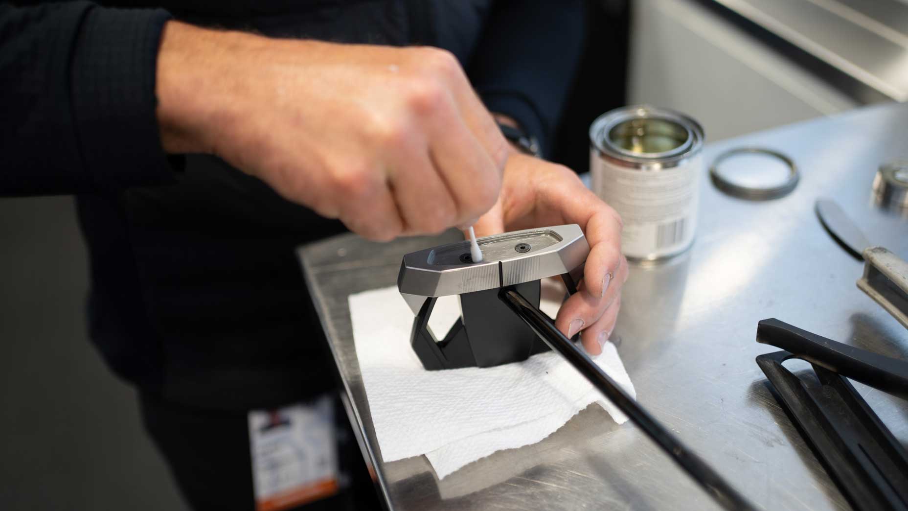 James Holley applies glue to a putter.
