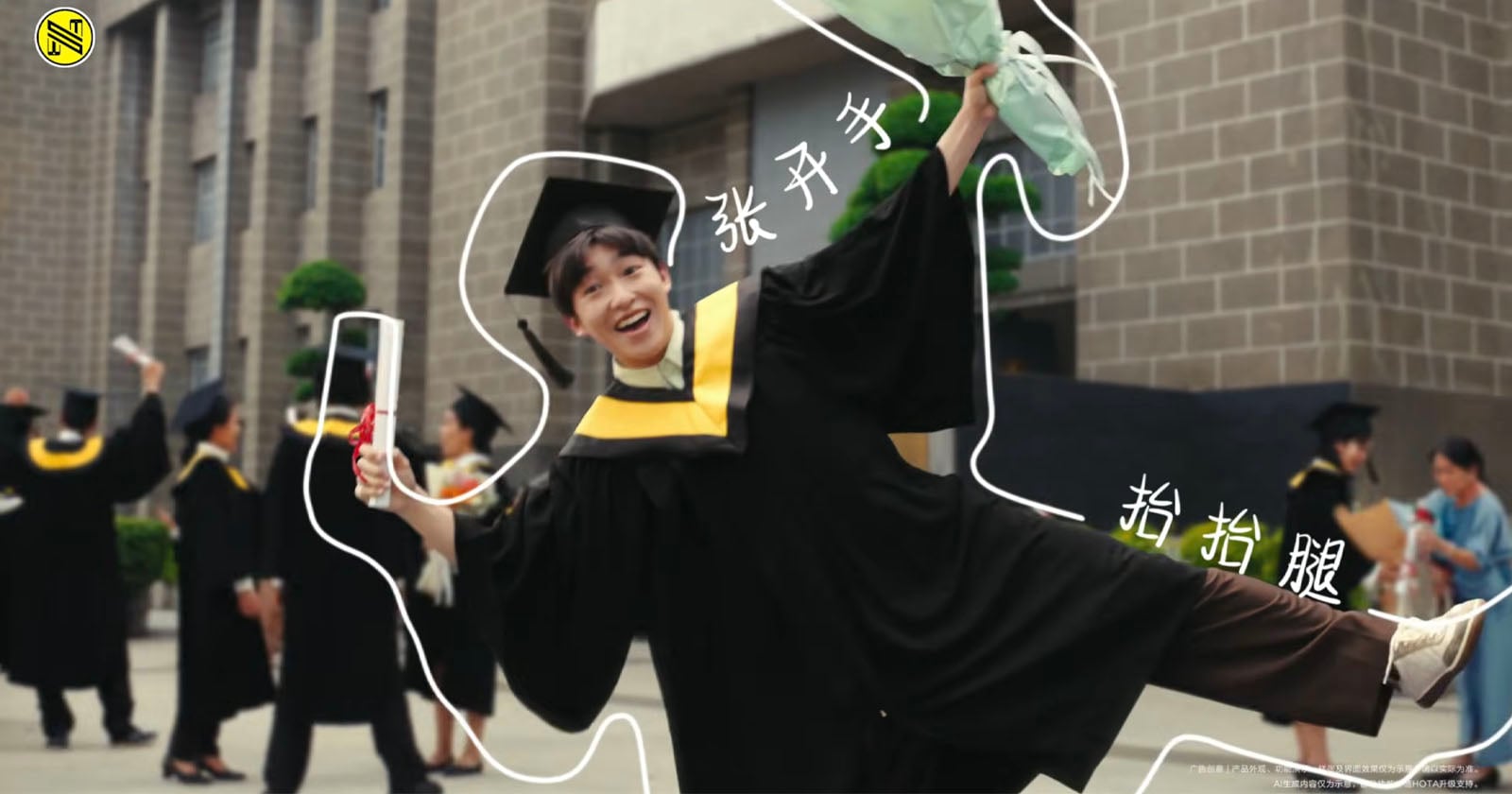 A person holds a smartphone showing an augmented reality outline of a graduate in cap and gown. In the background, people in graduation attire stand outside a building.