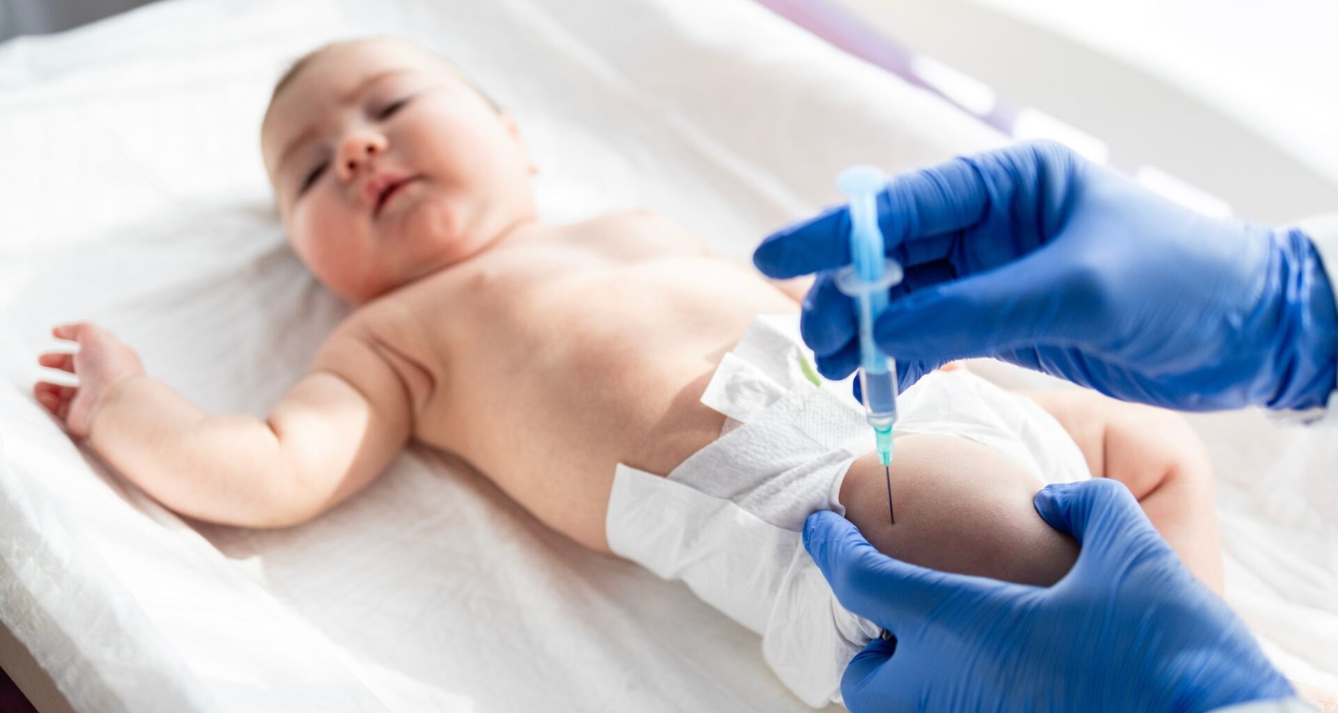 Doctor vaccinating baby newborn at maternity hospital.