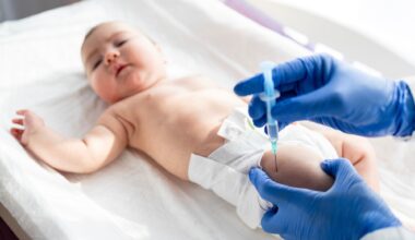 Doctor vaccinating baby newborn at maternity hospital.