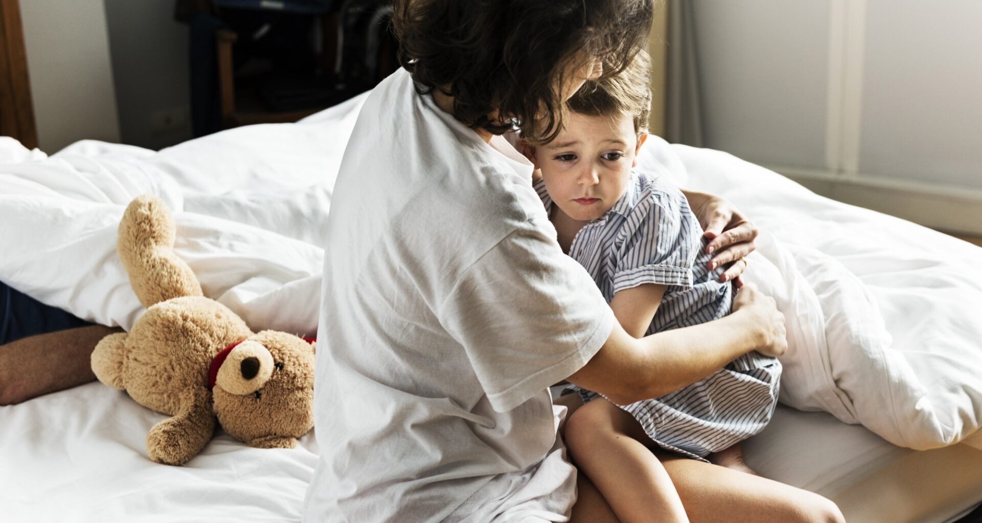 Mother hug and consoling the little boy from nightmare