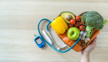 A hand holds a heart-shaped bowl filled with fresh healthy foods - including vegetables, fruit, fish, and nuts - next to a glucose meter and stethoscope, symbolizing diet and heart health management in diabetes.