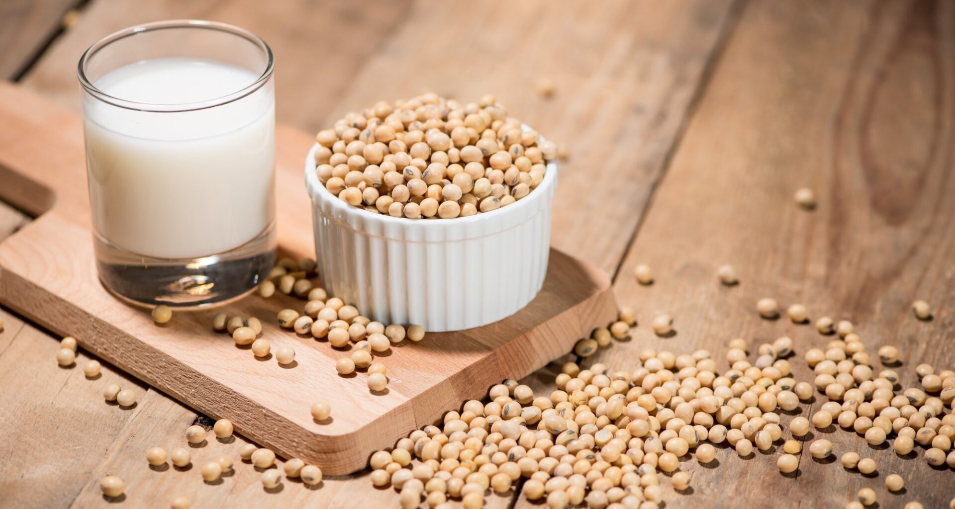 Soy milk or soya milk and soy beans on wooden table.