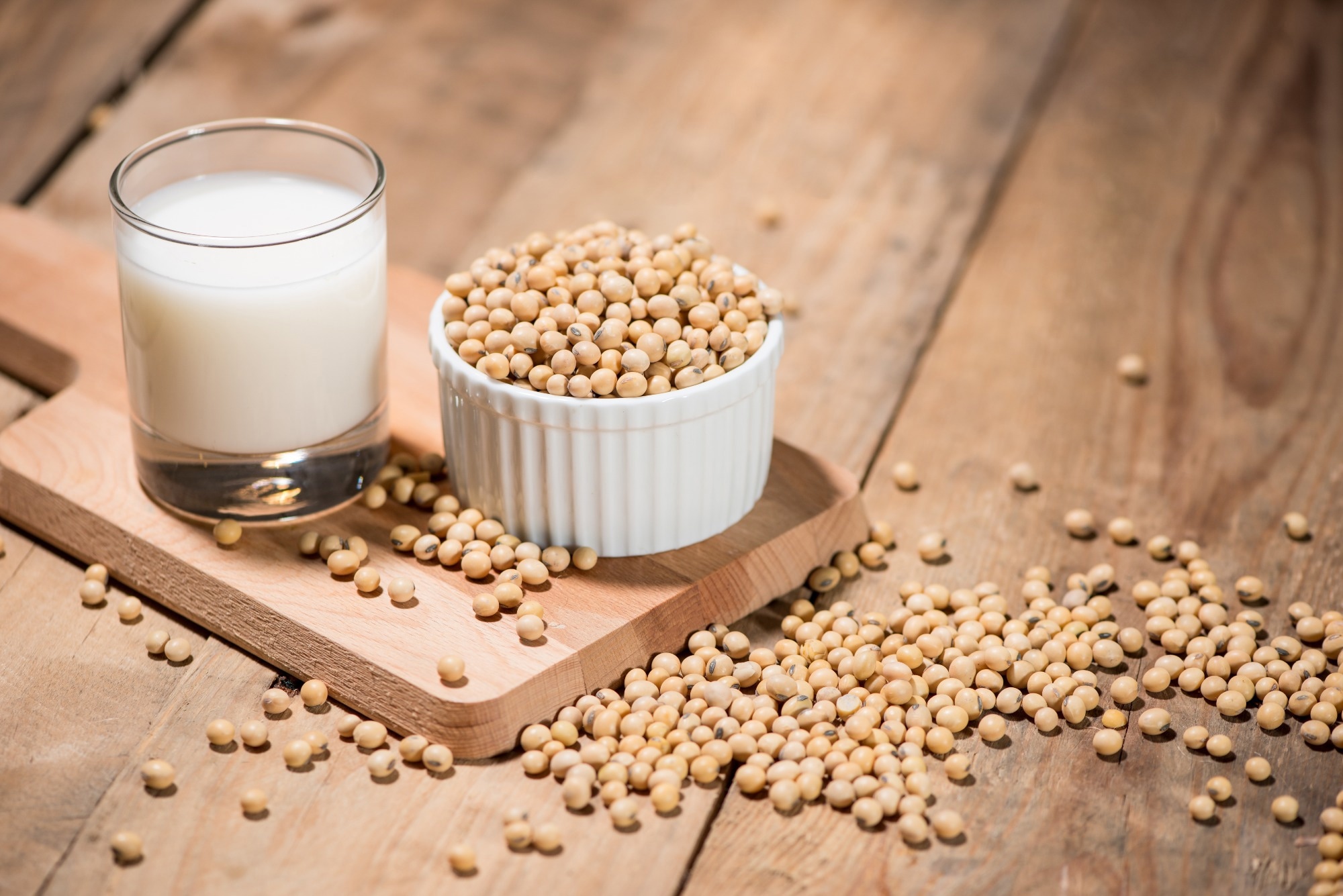 Soy milk or soya milk and soy beans on wooden table.