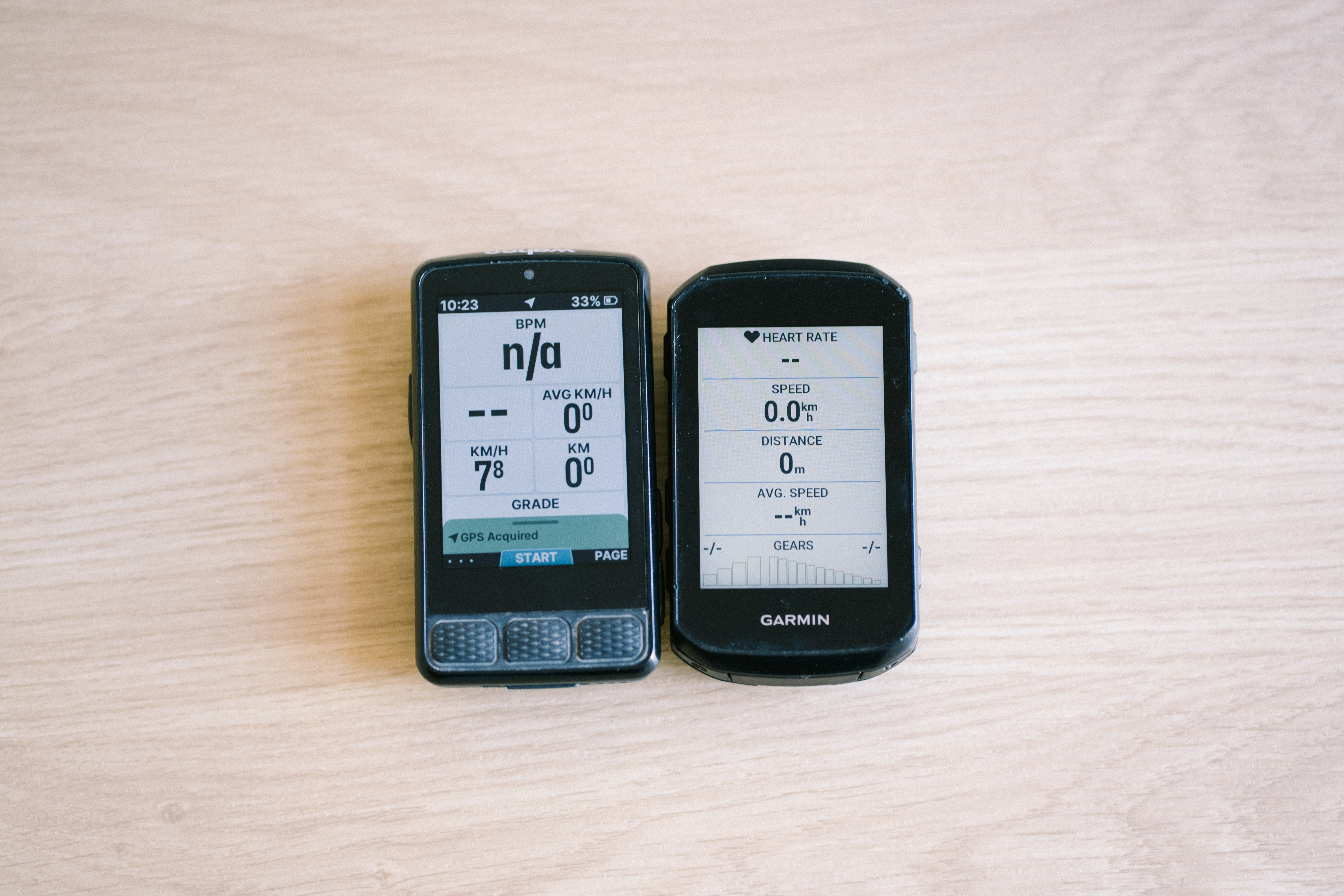 Bike computers on a table top showing different data screens