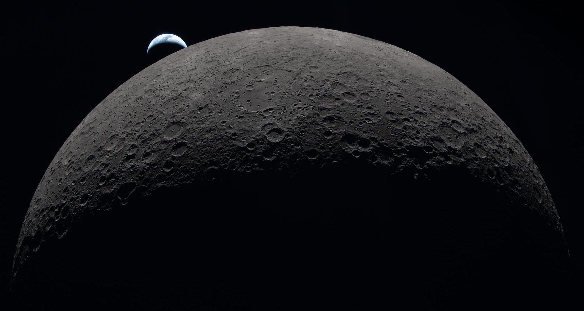 The upper half of the moon, partially lit, with a small crescent-shaped Earth in the background