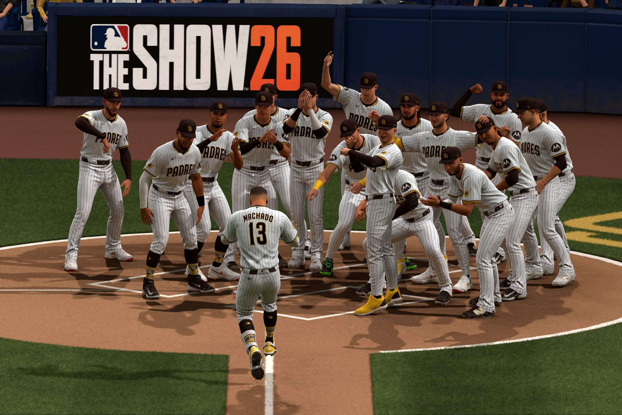 A graphic from MLB The Show 26 showing Padres players celebrating at the plate as Manny Machado runs down the third-base line.