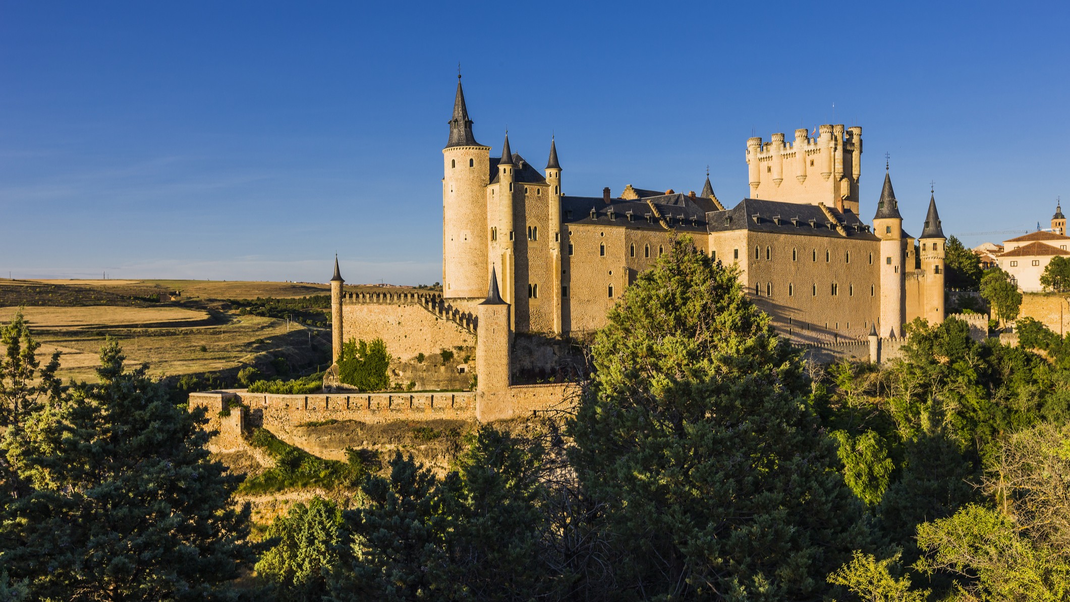 an impressive castle with tall turrets against a blue sky.