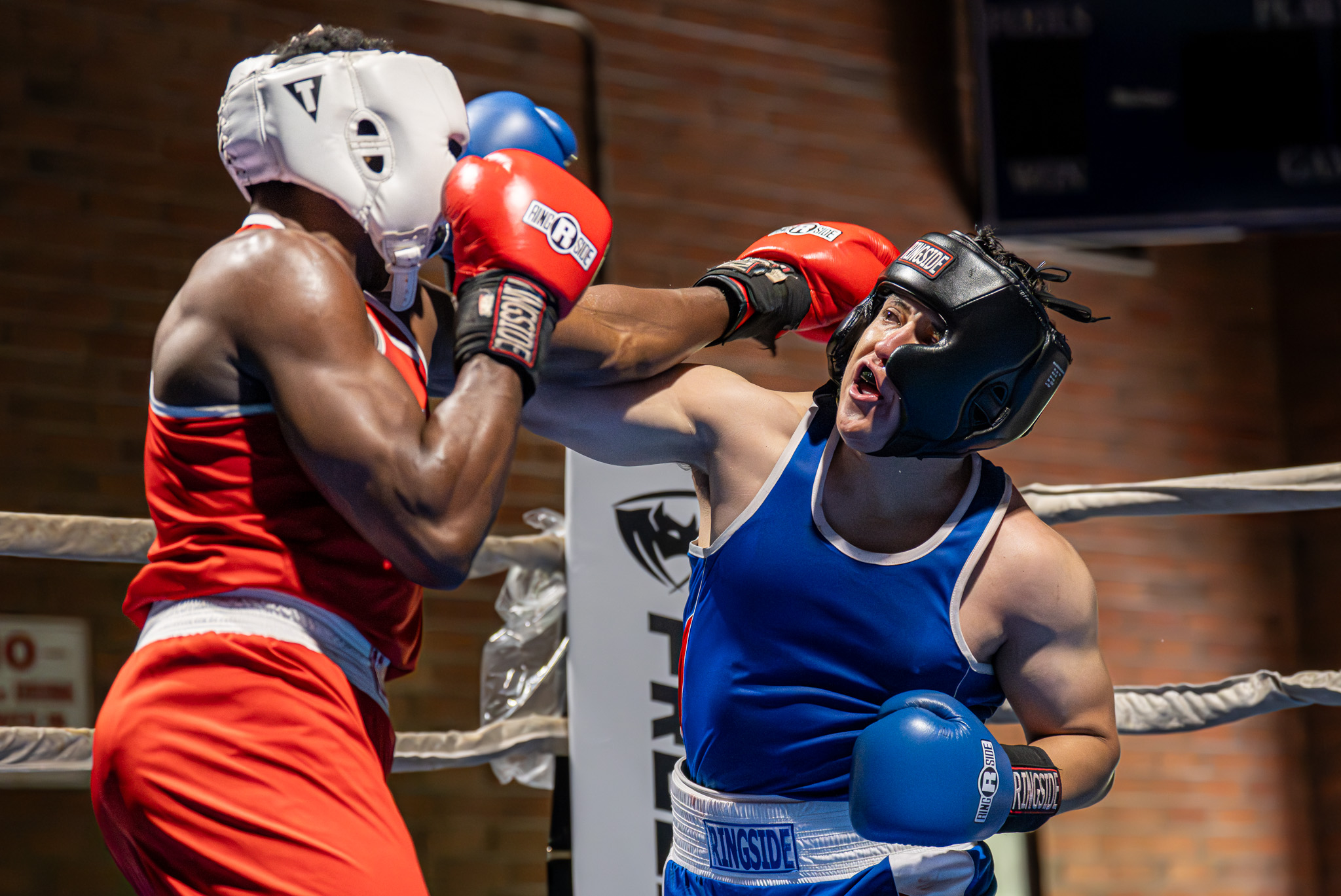 Omar Escobar (Blue) lands a right-handed punch against Reuben Flowers...