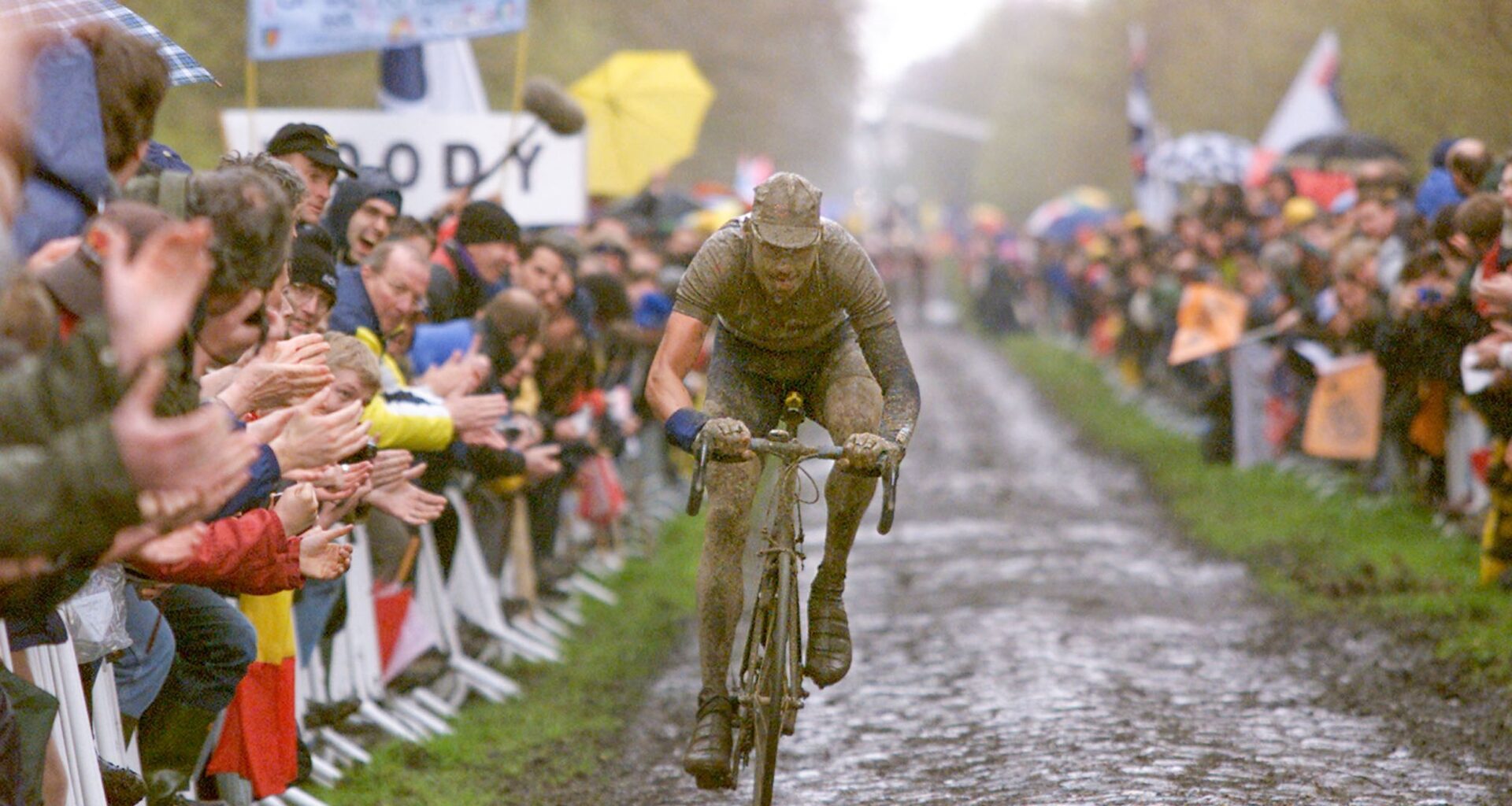 A muddy Wilfried Peeters races through the Arenberg Forest during the 2001 Paris-Roubaix, one of the iconic editions in the recent history of the race