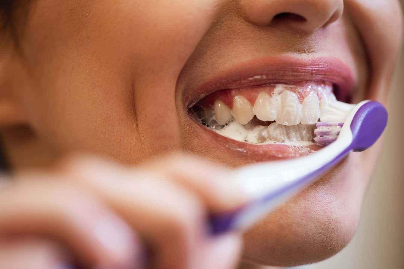 Close-up of woman brushing her teeth.